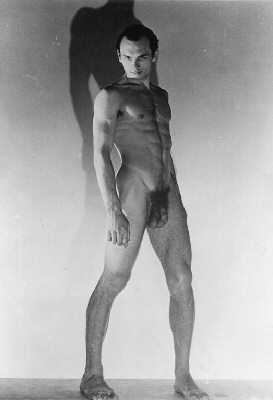 Yul Brynner standing in strong upward light